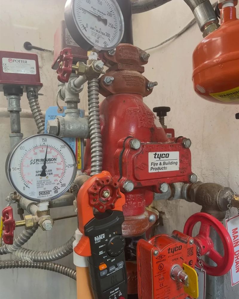 Dry pipe valve riser with sprinkler gauges during an inspection