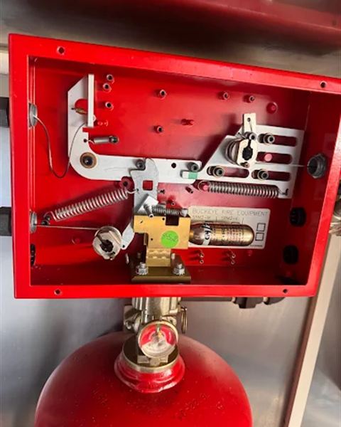 Open Buckeye kitchen suppression control head above its agent cylinder